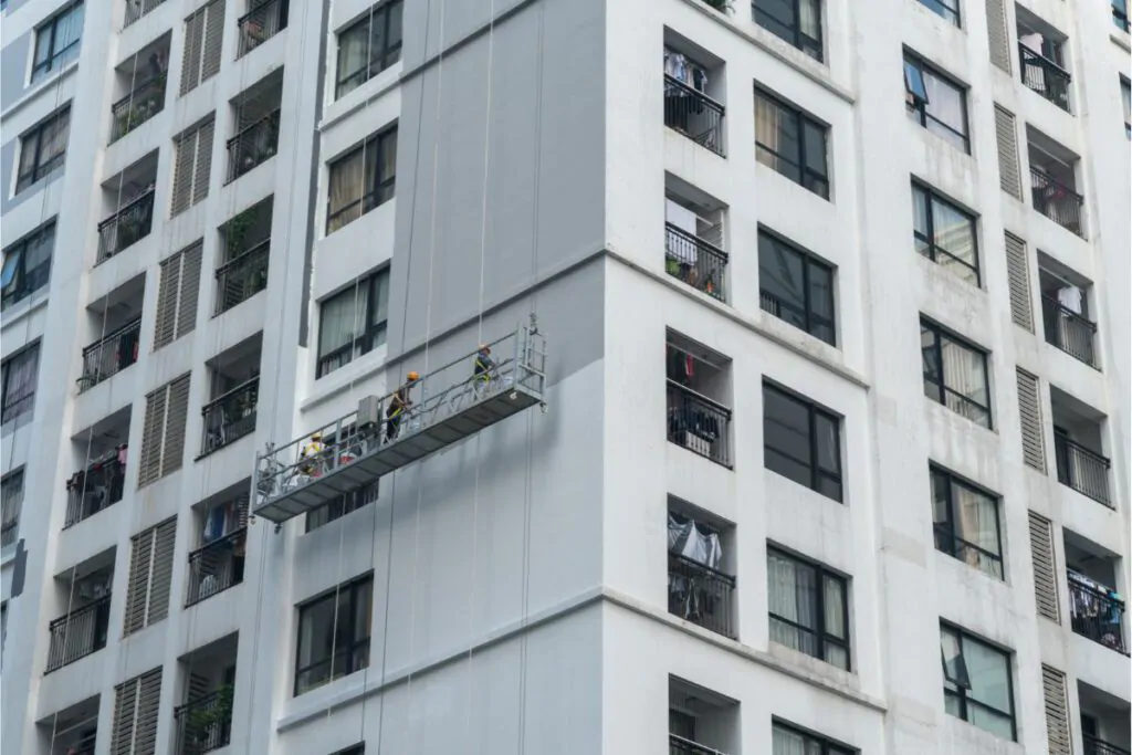 workers painting exterior of high rise- building